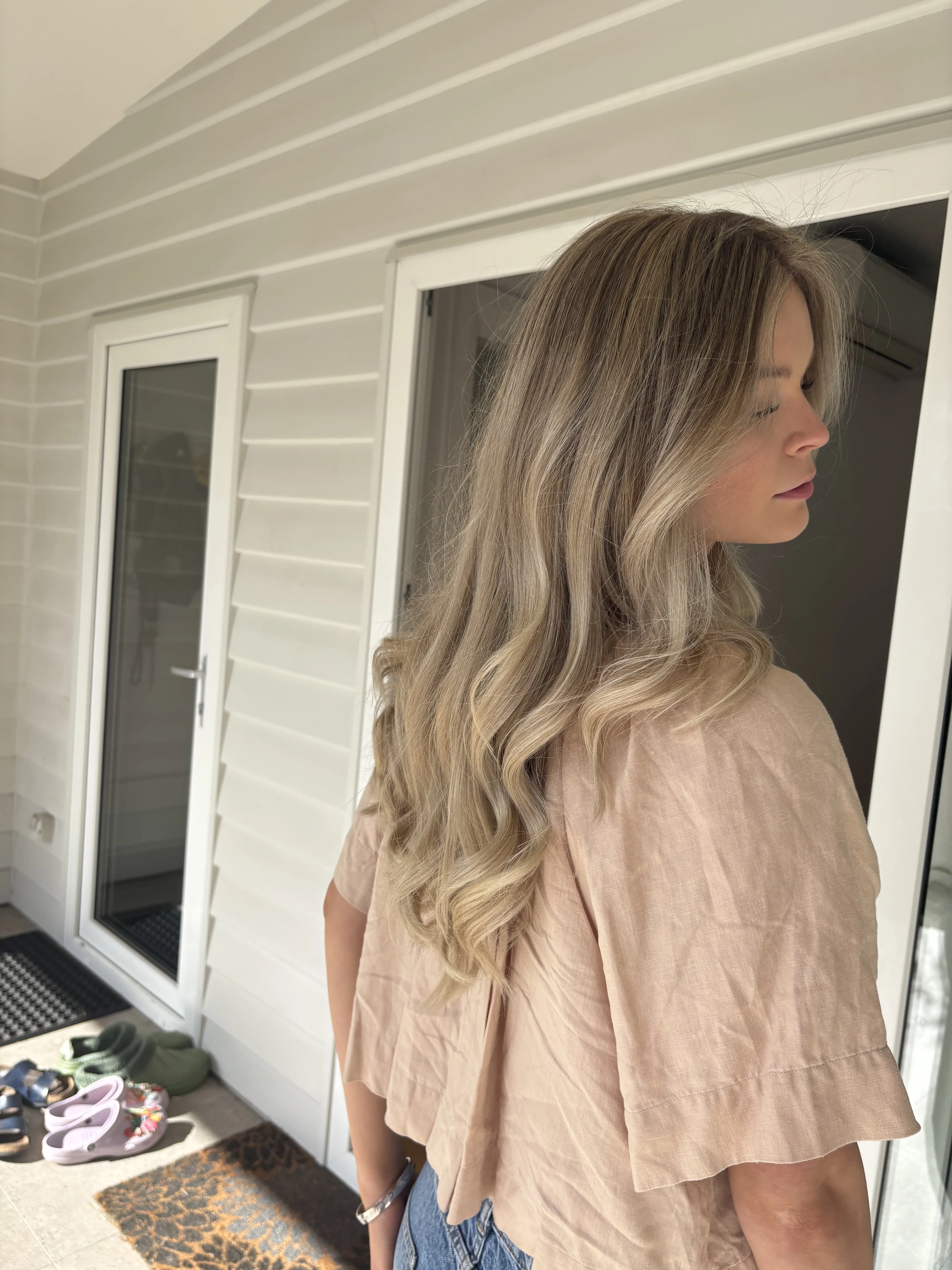 Beige blonde balayage soft waves on a sun-lit porch