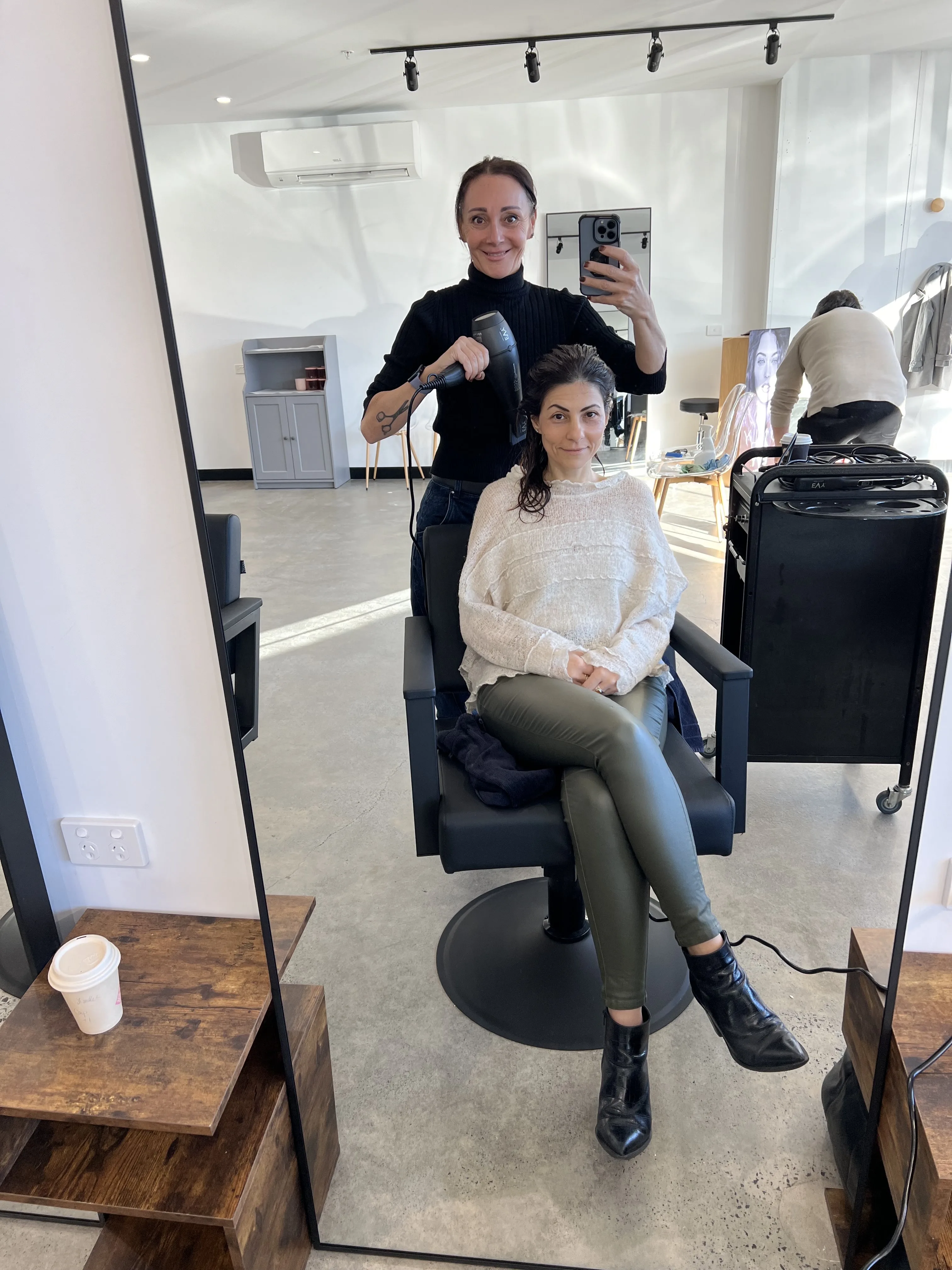 A Tone Salon stylist at work — blow-drying a client in the studio space